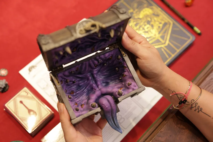 Opening the Mimic Dice Box beside an open rulebook