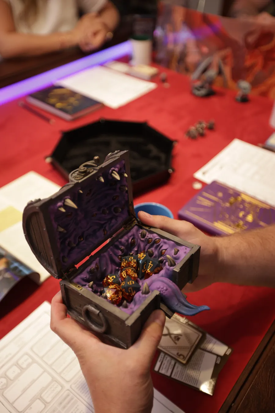 The open Mimic Dice Box full of dice, held at the table