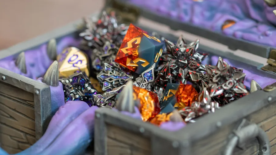 Close view of the Mimic Dice Box full of metal dice, tongue out